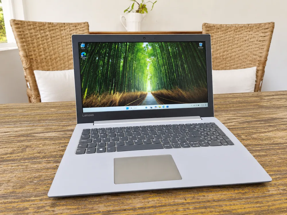 Notebook Lenovo i5 de 8ª geração aberto sobre mesa de madeira